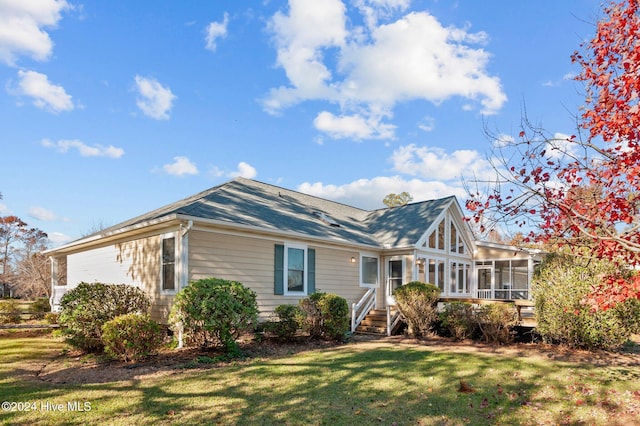 view of front of house featuring a sunroom and a front lawn