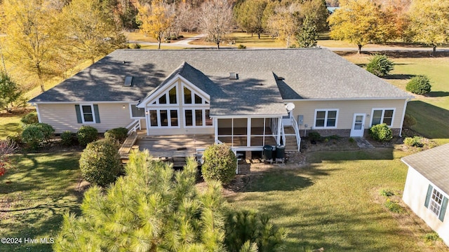 back of property featuring a sunroom, a deck, and a yard