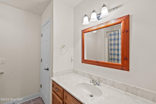 bathroom featuring a shower with shower curtain, vanity, and a textured ceiling