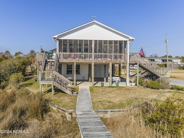 rear view of property with a sunroom and a patio area