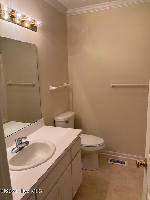 bathroom featuring vanity, toilet, and crown molding
