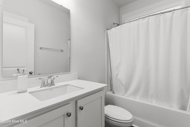 full bathroom featuring shower / tub combo with curtain, vanity, and toilet