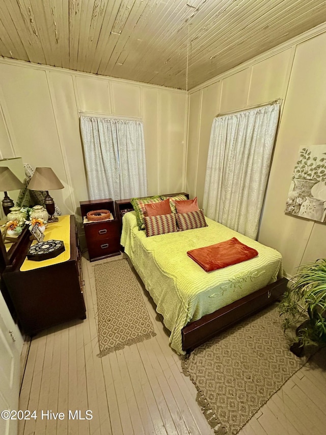 bedroom with light hardwood / wood-style flooring and wooden ceiling