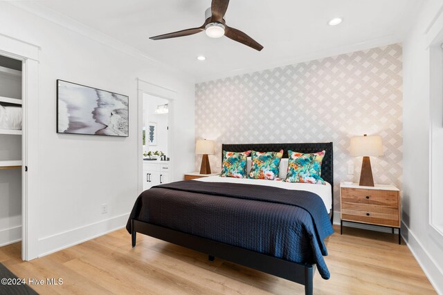 bedroom with ceiling fan, light hardwood / wood-style floors, crown molding, and ensuite bathroom