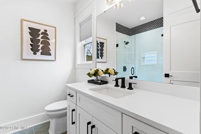 bathroom featuring toilet, vanity, tile patterned floors, and walk in shower