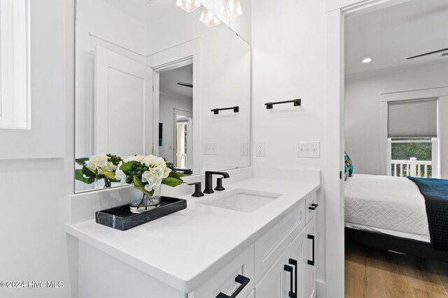 bathroom featuring hardwood / wood-style floors, vanity, and crown molding