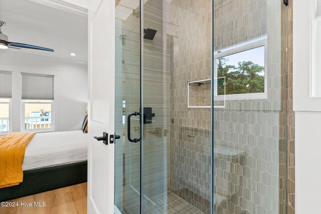 bathroom featuring hardwood / wood-style flooring, ceiling fan, and a shower with door