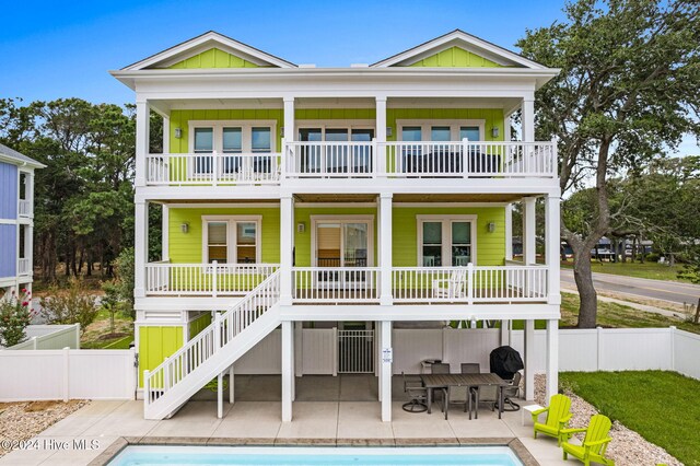 rear view of house featuring a fenced in pool and a patio area