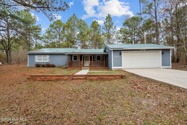 ranch-style home featuring covered porch and a garage