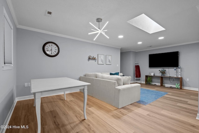 living room with a skylight, light hardwood / wood-style flooring, a chandelier, and ornamental molding