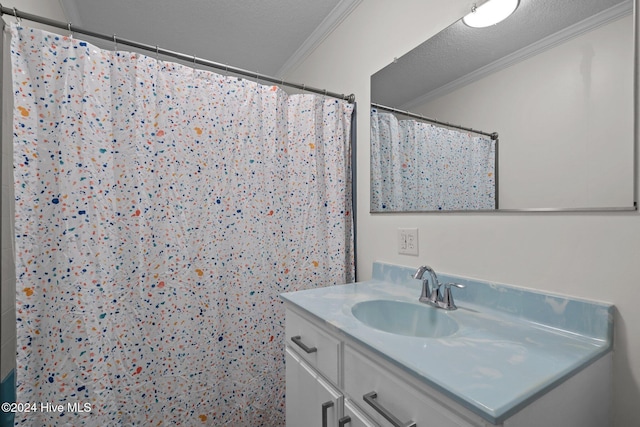 bathroom with vanity, a textured ceiling, walk in shower, and crown molding