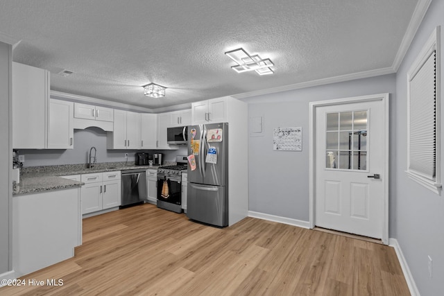 kitchen featuring light hardwood / wood-style flooring, a textured ceiling, light stone counters, white cabinetry, and stainless steel appliances