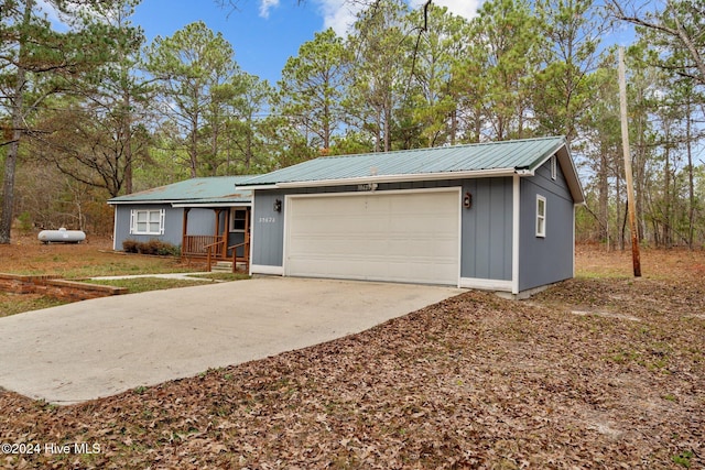 single story home featuring a porch and a garage