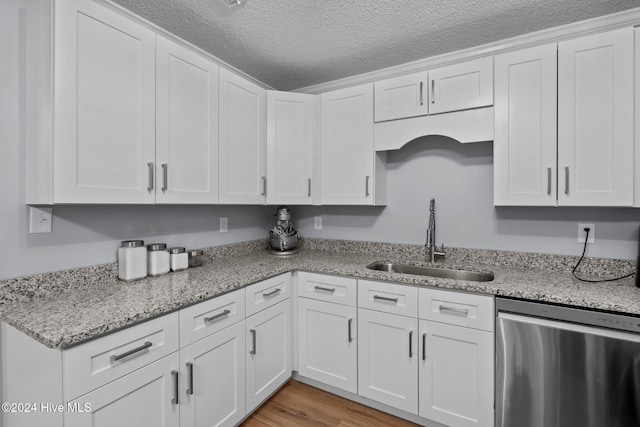 kitchen featuring white cabinetry, dishwasher, a textured ceiling, and sink