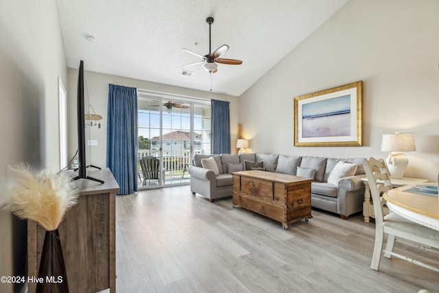 living room featuring ceiling fan, light hardwood / wood-style floors, a textured ceiling, and high vaulted ceiling