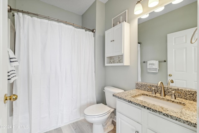 bathroom featuring a shower with shower curtain, wood-type flooring, vanity, and toilet