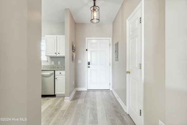 interior space featuring electric panel and light hardwood / wood-style flooring