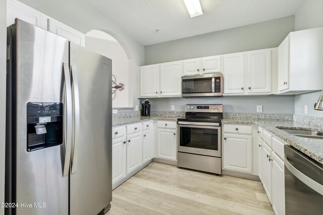 kitchen featuring light hardwood / wood-style flooring, white cabinets, stainless steel appliances, and sink