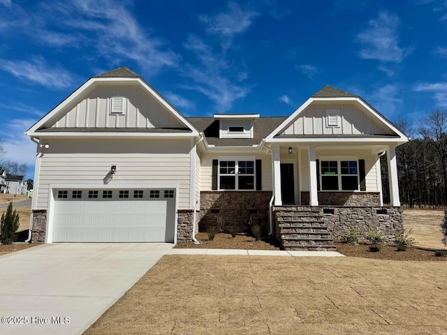 view of front facade with stone siding, a porch, board and batten siding, and concrete driveway