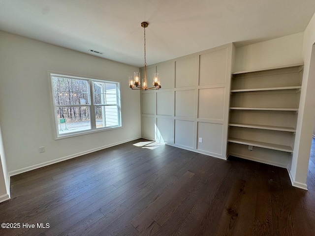 unfurnished dining area featuring baseboards, visible vents, a chandelier, and dark wood-type flooring