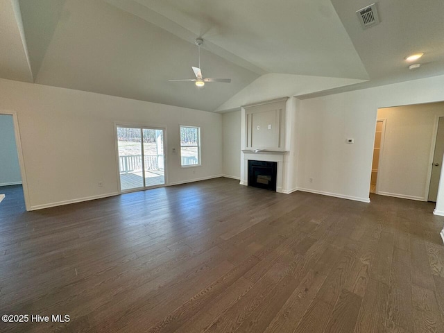 unfurnished living room featuring dark wood-style floors, a fireplace, lofted ceiling, visible vents, and ceiling fan