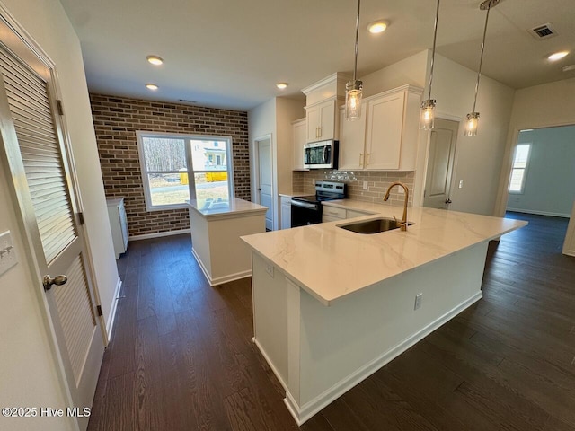 kitchen with dark wood-style floors, a center island, stainless steel appliances, white cabinets, and a sink