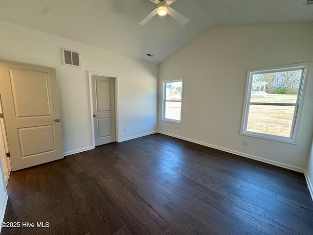 interior space featuring dark wood-style flooring, visible vents, vaulted ceiling, and baseboards