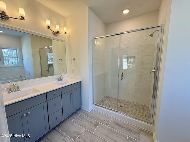 full bath with double vanity, a stall shower, and a sink