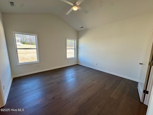 empty room with visible vents, baseboards, vaulted ceiling, a ceiling fan, and dark wood-style floors