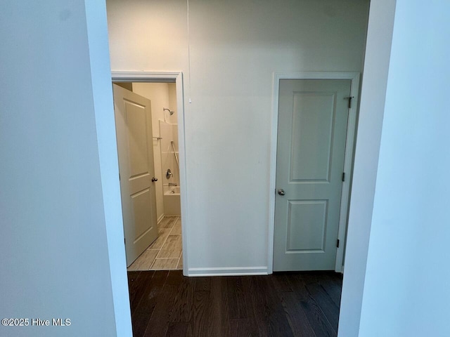 hallway featuring baseboards and wood finished floors