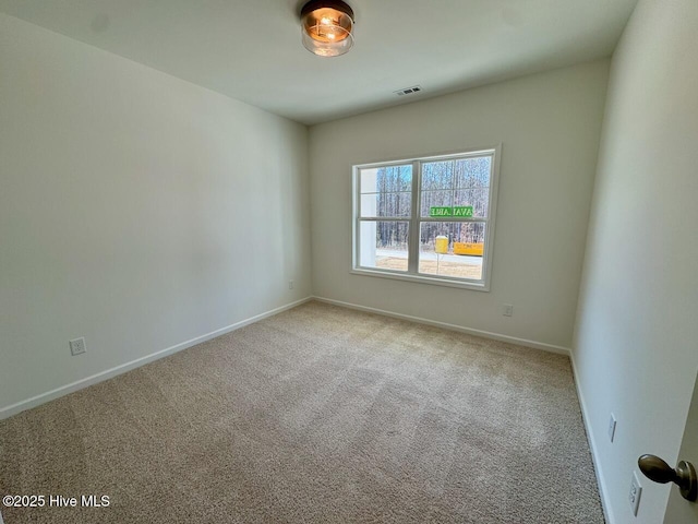 unfurnished room with carpet, visible vents, and baseboards