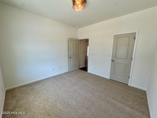 carpeted spare room featuring baseboards