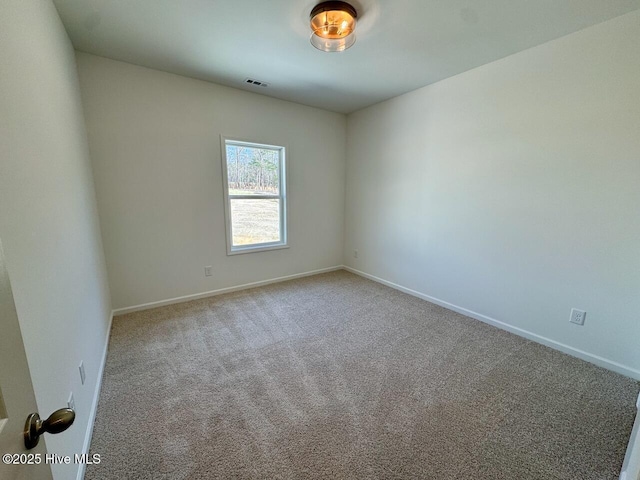 carpeted spare room with baseboards and visible vents