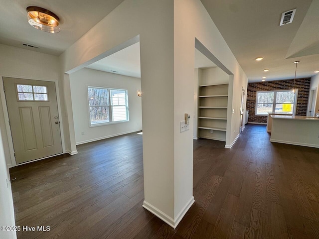 entrance foyer with visible vents, dark wood finished floors, and baseboards