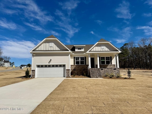 craftsman house featuring an attached garage, stone siding, board and batten siding, and concrete driveway