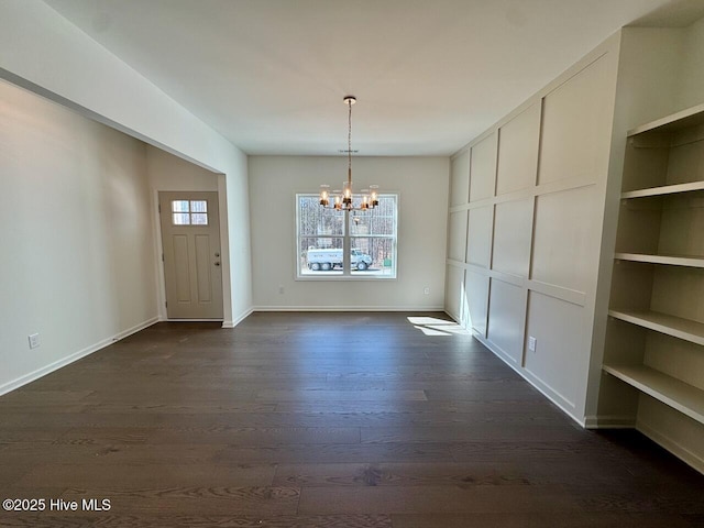 unfurnished dining area with baseboards, dark wood-type flooring, and an inviting chandelier