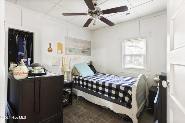 bedroom with ceiling fan and a drop ceiling