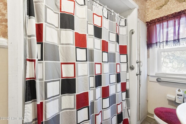 bathroom featuring toilet and walk in shower