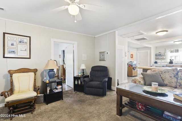 carpeted living room with ceiling fan and crown molding