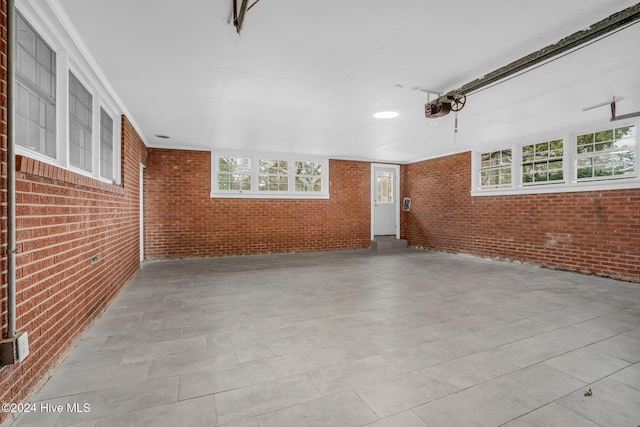 spare room featuring crown molding and brick wall