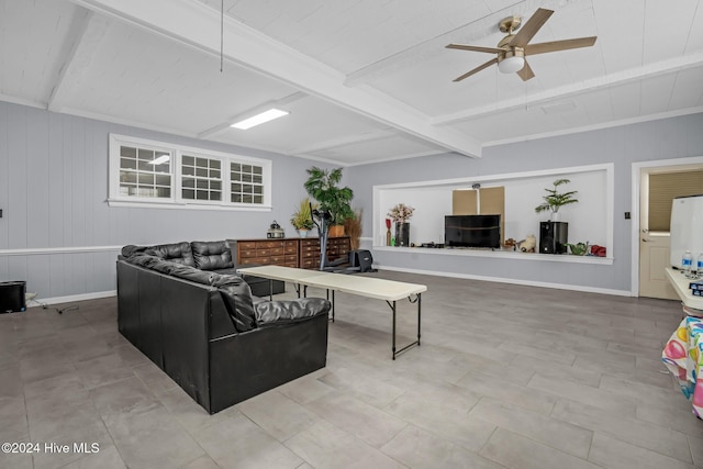 living room with ceiling fan, beamed ceiling, and wood walls