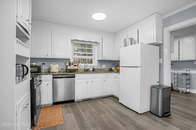 kitchen featuring appliances with stainless steel finishes, dark stone counters, sink, light hardwood / wood-style flooring, and white cabinets