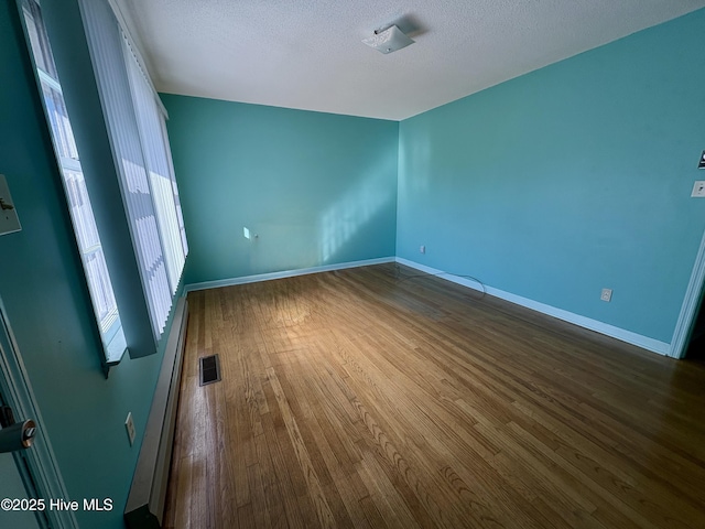 spare room with hardwood / wood-style flooring and a textured ceiling