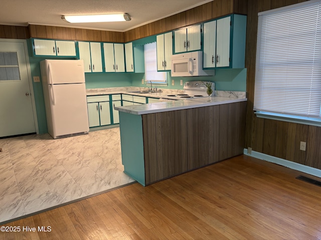 kitchen with sink, white appliances, kitchen peninsula, crown molding, and a textured ceiling