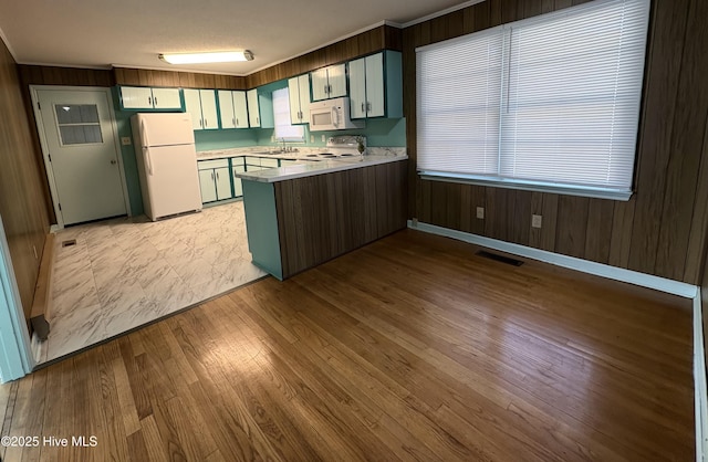 kitchen featuring sink, green cabinetry, a textured ceiling, kitchen peninsula, and white appliances