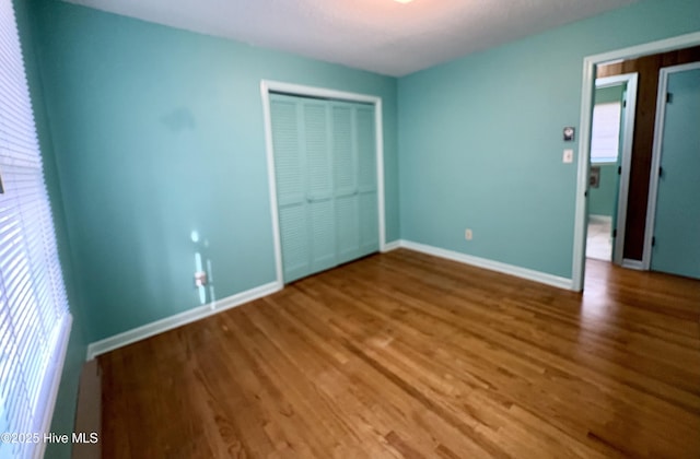 unfurnished bedroom featuring wood-type flooring and a closet