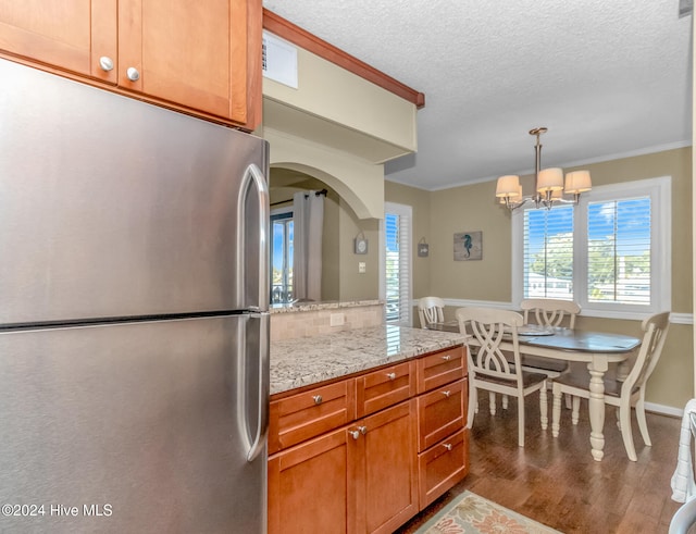 kitchen with a chandelier, stainless steel fridge, dark hardwood / wood-style flooring, and ornamental molding