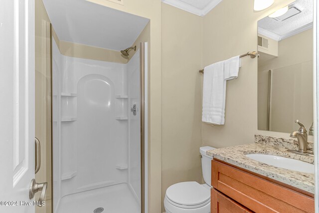 bathroom featuring a shower with shower door, toilet, ornamental molding, and vanity