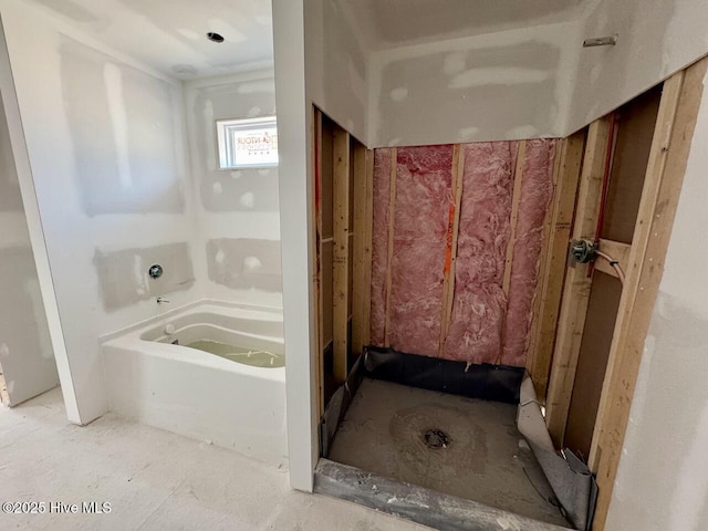 bathroom featuring a tub and a shower