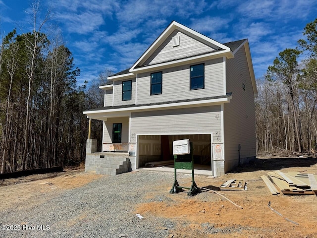 view of front of property featuring a porch and gravel driveway